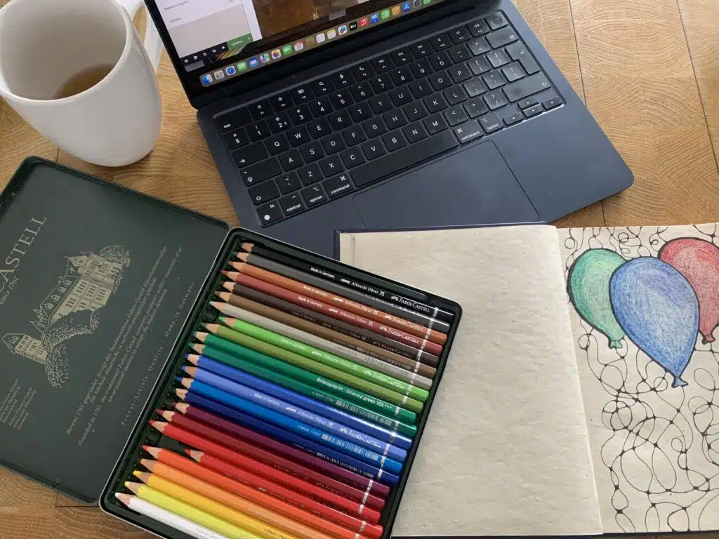 potloden, laptop, tekenboek en thee